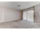 Spacious living room featuring carpet, neutral walls, and backyard access via sliding glass doors with vertical blinds at 4860 Nara Vista Way # 104, Las Vegas, NV 89103