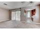 Living room with neutral walls, carpet, and view into the kitchen; backyard access via sliding glass door at 4860 Nara Vista Way # 104, Las Vegas, NV 89103