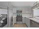 Modern kitchen features stainless steel appliances, gray cabinets, and wood look floors at 5129 Midnight Oil Dr, Las Vegas, NV 89122