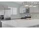 Close-up of a modern kitchen featuring stainless steel appliances and white quartz countertops at 5129 Midnight Oil Dr, Las Vegas, NV 89122