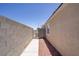 Narrow side yard with block wall and gravel, offering privacy at 5129 Midnight Oil Dr, Las Vegas, NV 89122