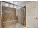 Walk-in shower with glass doors, a built-in seat, and tile walls at 5309 Tartan Hill Ave, Las Vegas, NV 89141