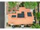 Aerial view of a terracotta tiled roof with solar panels in a meticulously landscaped yard with palm trees at 5609 Indian Ridge Dr, North Las Vegas, NV 89031