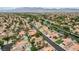 This aerial shows a residential neighborhood with mature trees, tile roofs, and mountain views at 5609 Indian Ridge Dr, North Las Vegas, NV 89031