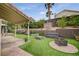 The backyard features multiple seating areas, an outdoor fire pit, and artificial turf at 5609 Indian Ridge Dr, North Las Vegas, NV 89031