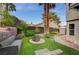 The backyard features a manicured lawn, an outdoor fire pit, and lush landscaping at 5609 Indian Ridge Dr, North Las Vegas, NV 89031