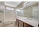 Neutral bathroom featuring a shower-tub, dark brown vanity, large mirror and frosted window for bright natural light at 5609 Indian Ridge Dr, North Las Vegas, NV 89031