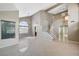 Open-concept living room with tile floors, a staircase, and ample natural light from the large windows at 5609 Indian Ridge Dr, North Las Vegas, NV 89031