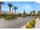 Welcoming entrance to community with palm trees, manicured landscaping, and elegant street lamps at 5940 Vizzi Ct, Las Vegas, NV 89131