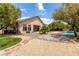 A view of the backyard with a covered patio, mature trees and access to the pool area at 6779 Rainstorm Ridge Ave, Las Vegas, NV 89131