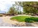 Large backyard featuring gravel landscaping, a small patch of lawn, and mature trees, offering privacy at 6779 Rainstorm Ridge Ave, Las Vegas, NV 89131