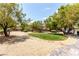 Expansive backyard with gravel landscaping, mature trees and partial view of RV parking area at 6779 Rainstorm Ridge Ave, Las Vegas, NV 89131