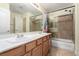 The bathroom features a double sink vanity, tile flooring, and bathtub shower combo at 6779 Rainstorm Ridge Ave, Las Vegas, NV 89131