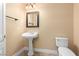 Cozy bathroom features a pedestal sink, framed mirror, and toilet at 6779 Rainstorm Ridge Ave, Las Vegas, NV 89131