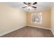 The bedroom features a ceiling fan, wood laminate flooring, cream colored walls, and large window at 6779 Rainstorm Ridge Ave, Las Vegas, NV 89131