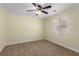 The bedroom features a ceiling fan, carpet flooring, cream colored walls, and a large window at 6779 Rainstorm Ridge Ave, Las Vegas, NV 89131