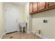 This laundry room features tile flooring, a utility sink, built in cabinets, and washer/dryer hookups at 6779 Rainstorm Ridge Ave, Las Vegas, NV 89131