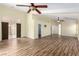 Large living area features wood-look flooring, doors to the exterior, and ceiling fans at 6779 Rainstorm Ridge Ave, Las Vegas, NV 89131