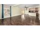 Spacious living room with wood floors, large windows, and an open view to the kitchen at 6779 Rainstorm Ridge Ave, Las Vegas, NV 89131