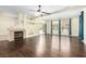 Open living room features dark wood floors, fireplace, ceiling fan, and sliding glass doors at 6779 Rainstorm Ridge Ave, Las Vegas, NV 89131