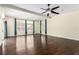 Bright living room with dark wood floors, large windows, and a ceiling fan at 6779 Rainstorm Ridge Ave, Las Vegas, NV 89131