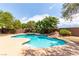 Inviting backyard pool featuring a rock waterfall, lush landscaping and a clear blue sky above at 6779 Rainstorm Ridge Ave, Las Vegas, NV 89131