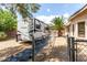 Gated RV parking area with a large RV, gravel landscaping, and mature trees for shade and privacy at 6779 Rainstorm Ridge Ave, Las Vegas, NV 89131