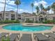 Community pool and spa, surrounded by lounge chairs, lush landscaping, and beautiful architecture at 6800 E Lake Mead Blvd # 2089, Las Vegas, NV 89156