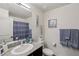 Well-lit bathroom features a granite countertop, neutral wall decor, and coordinating blue towels at 6807 Satin Silver Ct, North Las Vegas, NV 89086