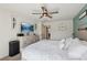 Well-lit bedroom with a large dresser, ceiling fan, and a mounted television screen at 6807 Satin Silver Ct, North Las Vegas, NV 89086