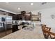Updated kitchen featuring dark cabinets, granite countertops, stainless steel appliances and barstool seating at 6807 Satin Silver Ct, North Las Vegas, NV 89086