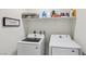 Practical laundry room with white washer and dryer, and shelving for storage at 6807 Satin Silver Ct, North Las Vegas, NV 89086