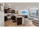 Open-concept living space flows into kitchen, with stainless steel appliances, island seating, and modern furnishings at 6807 Satin Silver Ct, North Las Vegas, NV 89086