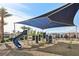 Vibrant playground with a slide, climbing structures, and sun shade for children in a Gathering neighborhood at 6807 Satin Silver Ct, North Las Vegas, NV 89086