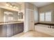 Bathroom featuring dual sinks, granite counters, separate tub and tiled flooring at 741 Flowing Meadow Dr, Henderson, NV 89014