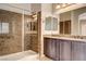 Bathroom featuring dual sinks, marble counters, mirrors and tiled glass shower at 741 Flowing Meadow Dr, Henderson, NV 89014
