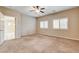 A neutral bedroom with two windows, ceiling fan, and access to the rest of the house at 741 Flowing Meadow Dr, Henderson, NV 89014