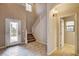 Bright foyer boasts tile flooring, a decorative glass door, and staircase leading to the second level at 741 Flowing Meadow Dr, Henderson, NV 89014