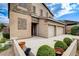 A tan two story house with a three car garage shows manicured landscaping and a well kept driveway at 741 Flowing Meadow Dr, Henderson, NV 89014
