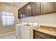 Laundry room features cabinetry, countertop, window, washer and dryer at 741 Flowing Meadow Dr, Henderson, NV 89014