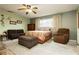 Cozy bedroom featuring a ceiling fan, closet and a comfortable seating area at 7701 Pheasant Ln, Las Vegas, NV 89145