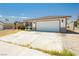 Single story home with two car garage and desert landscaping at 7701 Pheasant Ln, Las Vegas, NV 89145