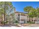 A charming condo with well-maintained landscaping, colorful flowers, and inviting stair access at 7961 Lions Rock Way # 202, Las Vegas, NV 89128