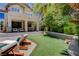 Backyard featuring a lush lawn, lounge chairs, and a covered patio, perfect for outdoor enjoyment and relaxation at 7988 Pinnacle Peak Ave, Las Vegas, NV 89113