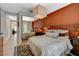 Bedroom with rust colored accent wall, bed with decorative pillows, and sliding mirror doors at 7988 Pinnacle Peak Ave, Las Vegas, NV 89113
