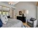 Bedroom with a view of the yard, neutral tones, and stylish decor with gray accent chair at 7988 Pinnacle Peak Ave, Las Vegas, NV 89113