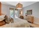 A cozy bedroom features neutral tones, a light wood dresser, and a door leading to a patio at 7988 Pinnacle Peak Ave, Las Vegas, NV 89113