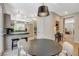 Bright dining area with black table, modern lighting, and views to the updated kitchen at 7988 Pinnacle Peak Ave, Las Vegas, NV 89113