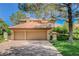 Charming two-story home with a red tile roof, mature trees, and a spacious three-car garage at 7988 Pinnacle Peak Ave, Las Vegas, NV 89113