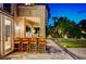 Outdoor patio featuring a bar, chairs, and lush landscaping with artificial turf, ideal for outdoor living and entertaining at 7988 Pinnacle Peak Ave, Las Vegas, NV 89113